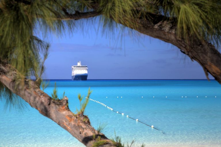 A ship waits on the horizon on a beautiful beach in the Caribbean.